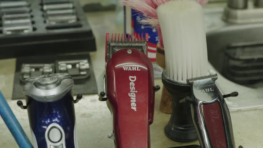 A row of razors and clippers sit at a barbers station