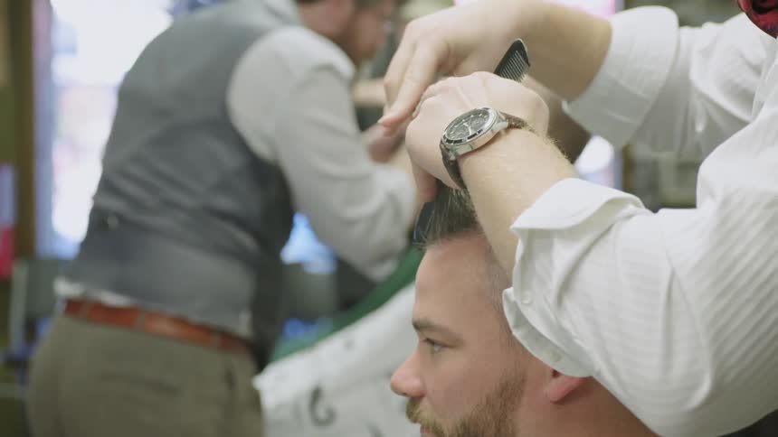 A barber working in a busy barber shop