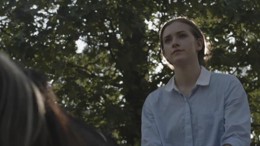 Woman rides a horse through some trees