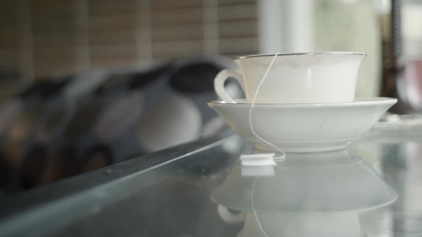 A steaming cup of tea is resting on a saucer
