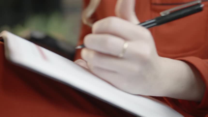 A woman writes on some forms
