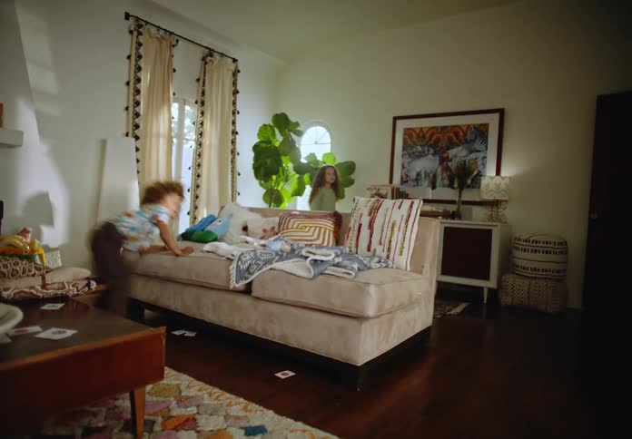 Two young girls play in a messy living room