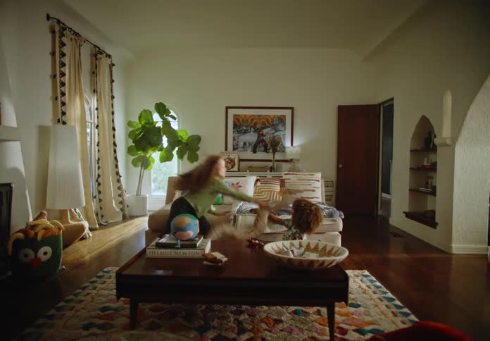 Two children in the room playing and hitting each other with the pillow