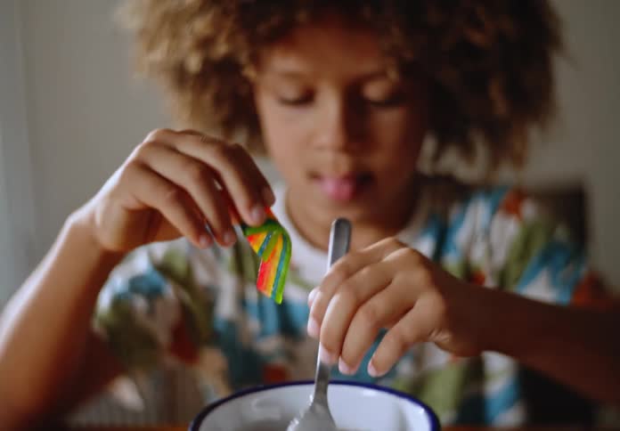 Young boy with a spoon tinkering with chocolate inside a cornflakes with milk