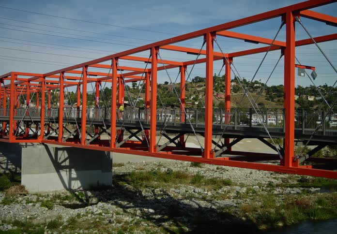 A person running on a neighborhood bridge during the day