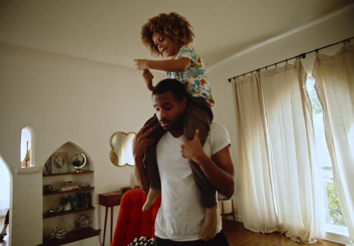 Father holding his son on his shoulders and walking around the room