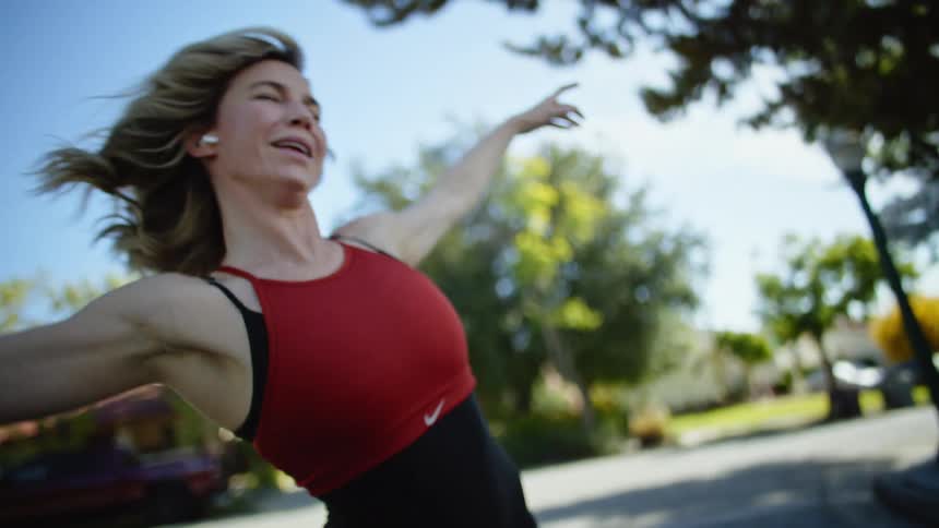 Blonde woman dances in residential street near an intersection
