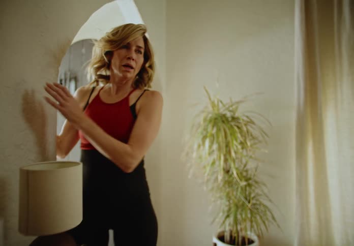 Woman entering her house looking at the living room and with a scared facial expression