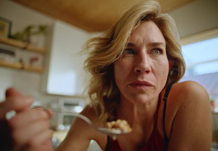 Portrait of a blonde woman eating cornflakes with milk