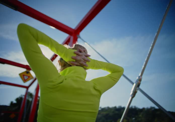 Blonde woman on a bridge stretching her arms