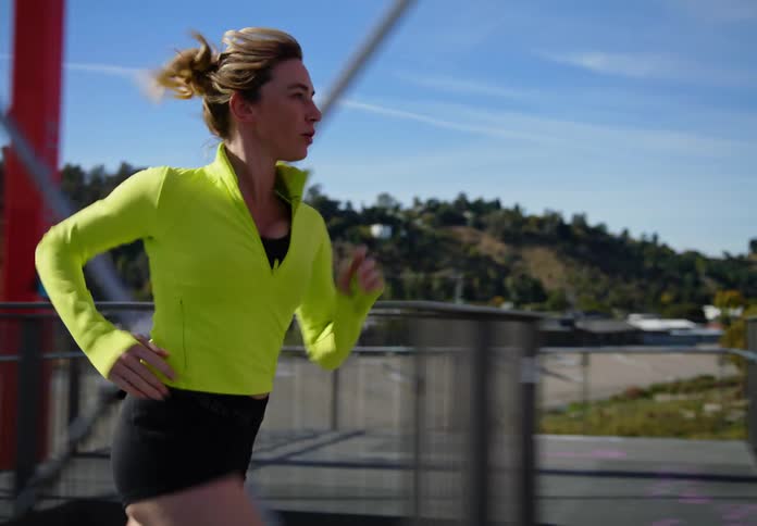 A lady running on a bridge during the day