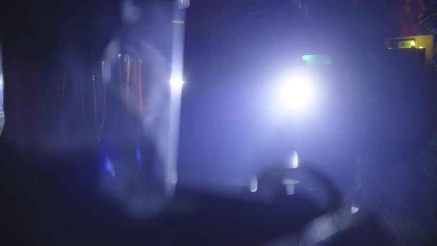 A flashlight being flashed across a dark room