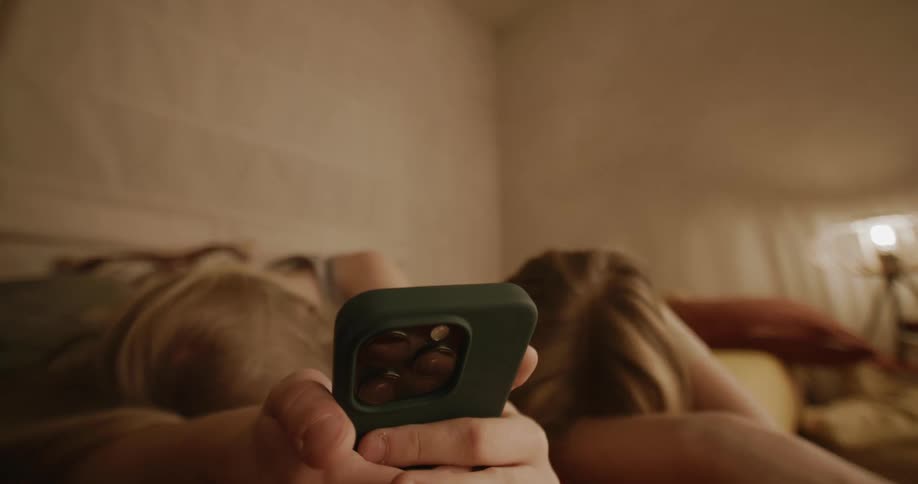 Teenagers laugh while looking at the cell phone