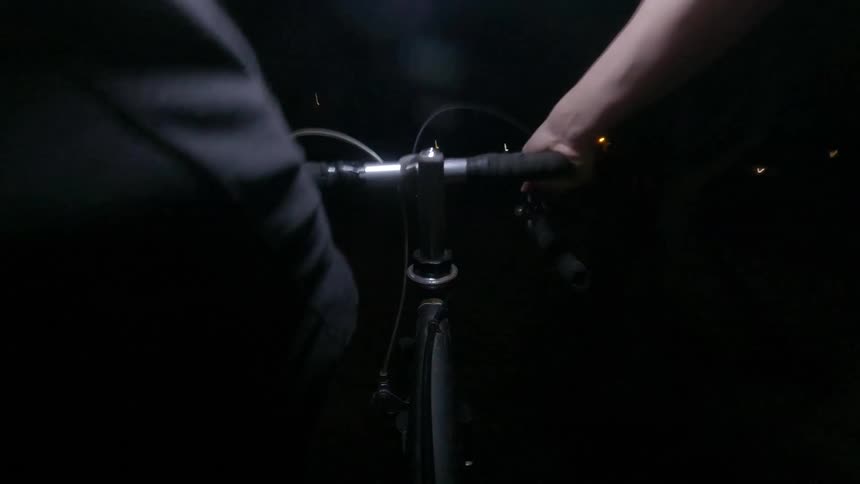 A man is riding a bike at night