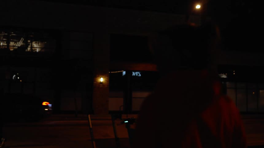 Woman walking at night on the streets of a metropolis with her back to the camera