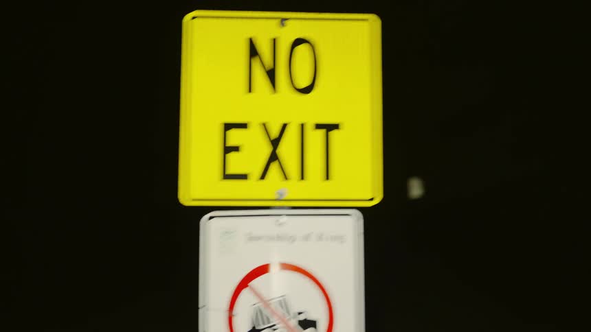 Two road signs in a location at night