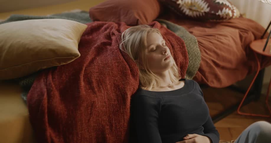 A teenager is resting by the bed