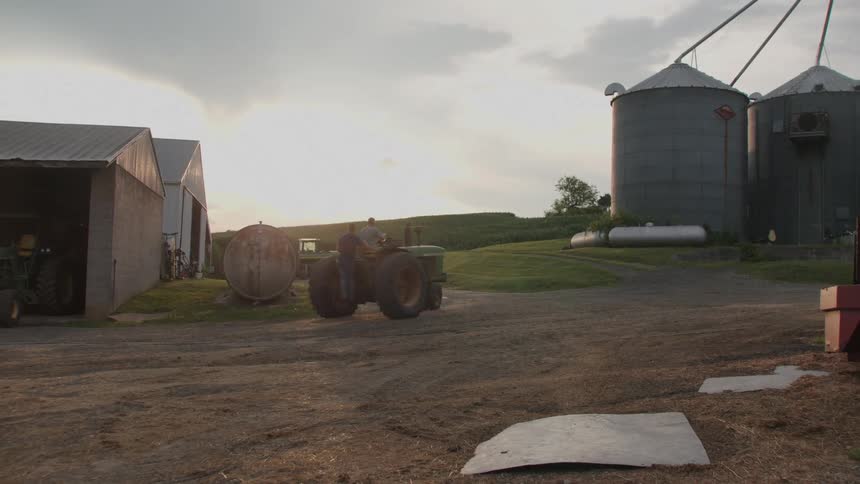 Man maneuvering a tractor and guarding inside a ranch on a farm