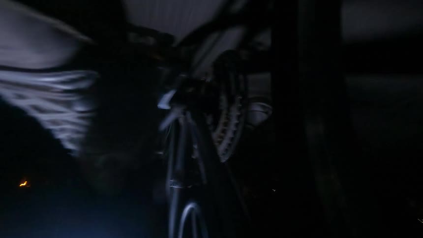 Closeup of a bicycle bearing with a person pedaling quickly at night