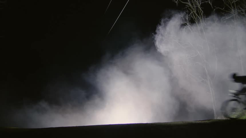 A cyclist pedals a bicycle at high speed in nature at night