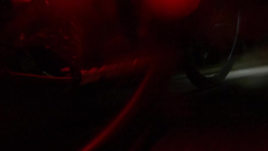 A person rides a bike at night