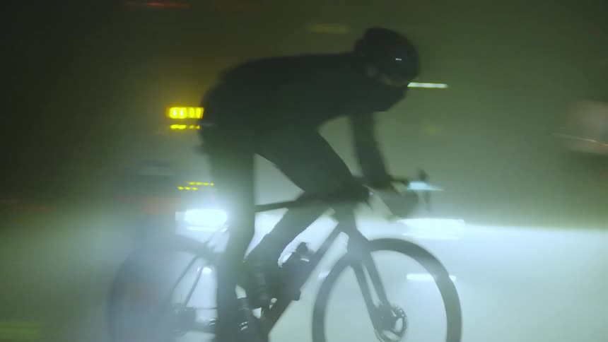 A person riding a bicycle at night on the city
