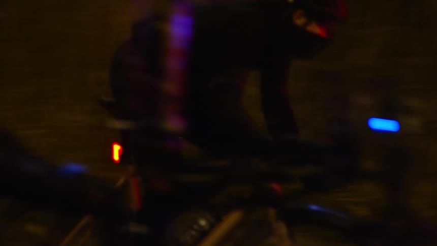 A bicyclist rides past a police car