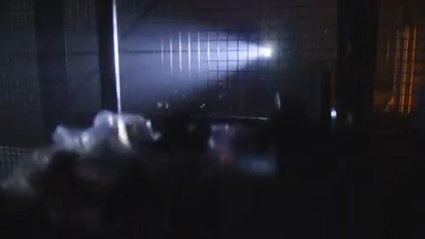 A masked man searches the dark room with a flashlight