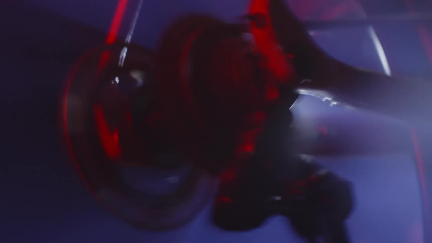 Bearing and wheel view of a man pedaling a bicycle at high speed at night