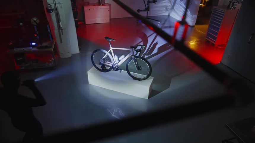 A burglar stealing a bicycle shines a light to the camera