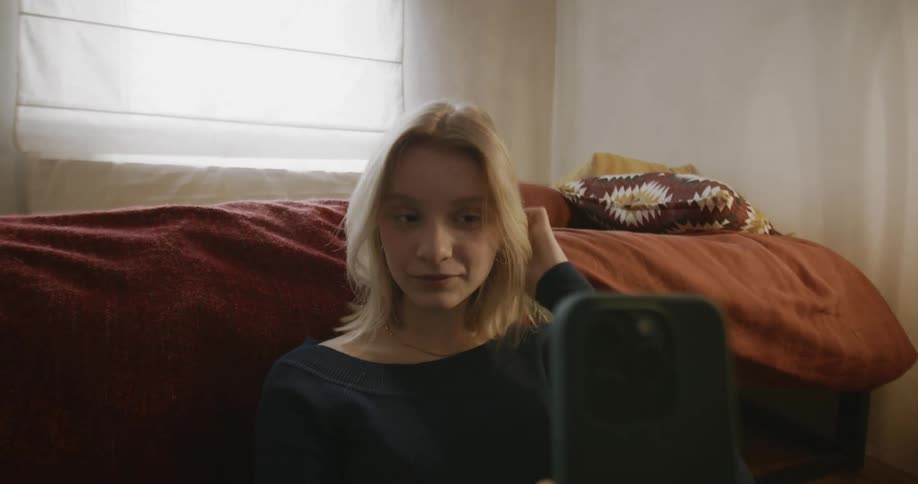 A girl smiles while looking at her phone