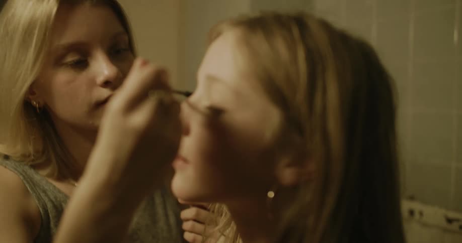 Friends putting on makeup in the bathroom