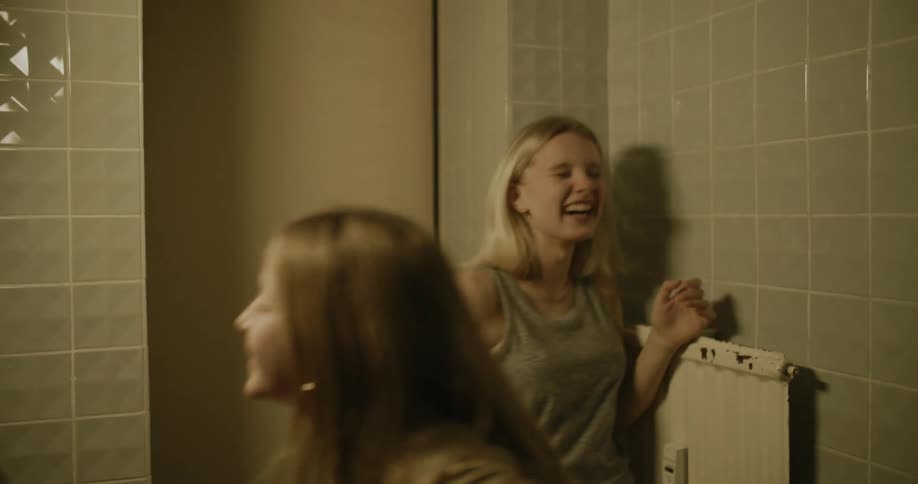 Two girls dance and sing in the bathroom