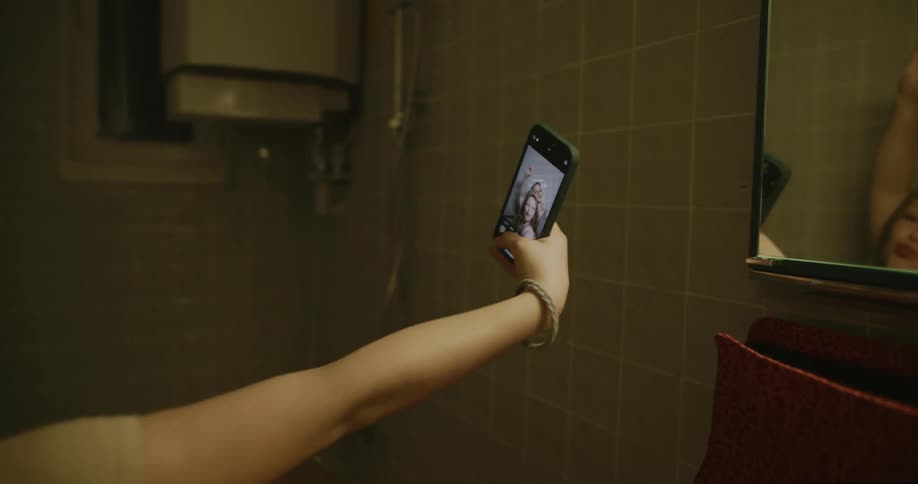 Sisters taking a selfie in front of the bathroom mirror