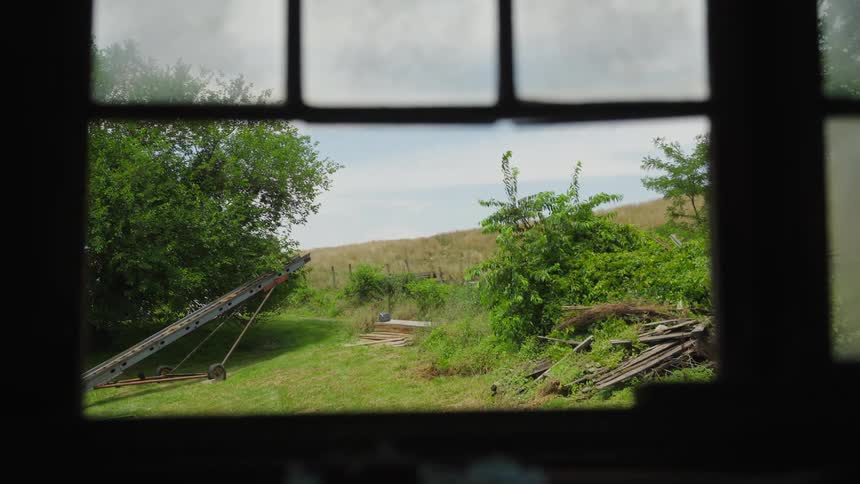 A farm field seen through an open window