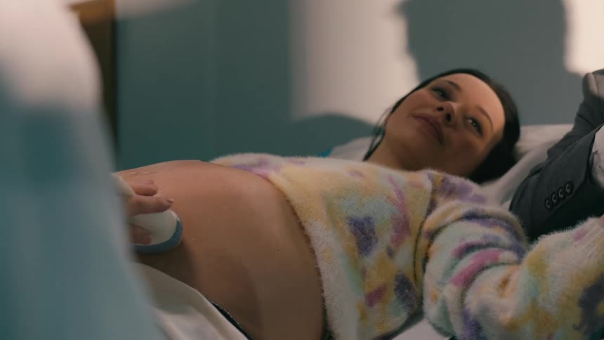 A person pregnant woman receiving an ultrasound examination by a doctor