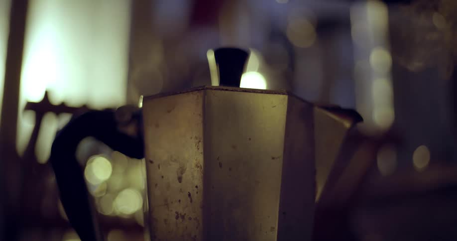 Steam comes out of a well used traditional style Italian coffee pot
