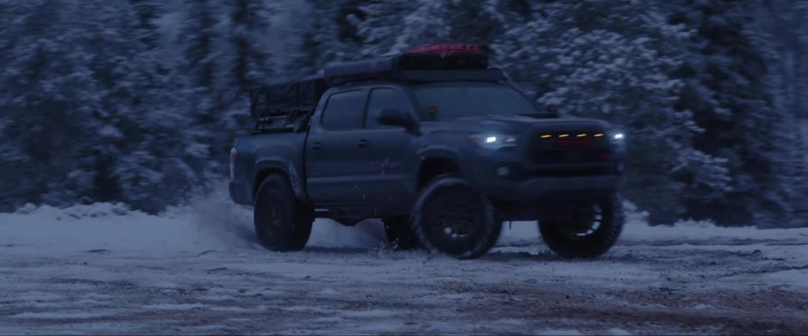 Pickup truck performing stunts on a snowy land at dawn