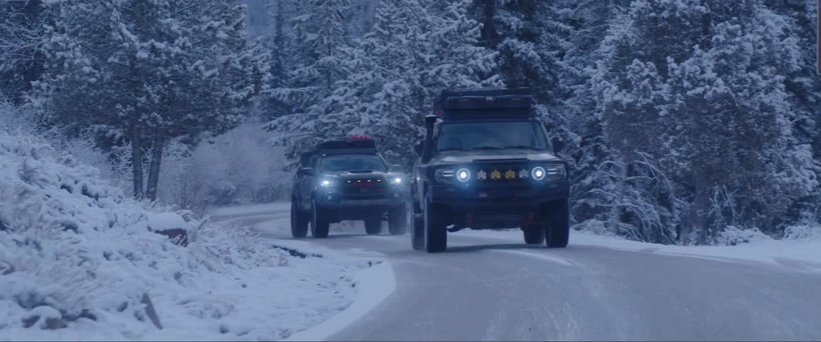 Cars driving on a deserted road in the snowcovered forest during winter