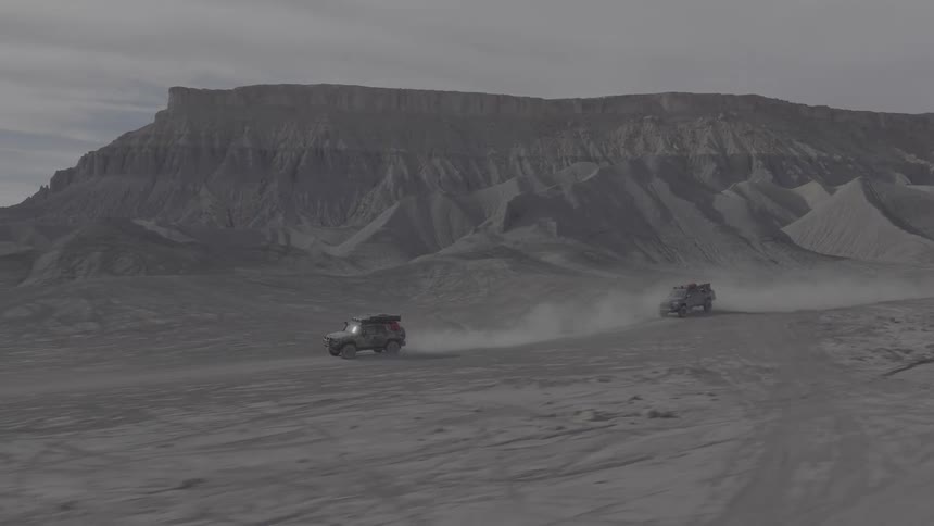 Two atv driving across a rocky desert