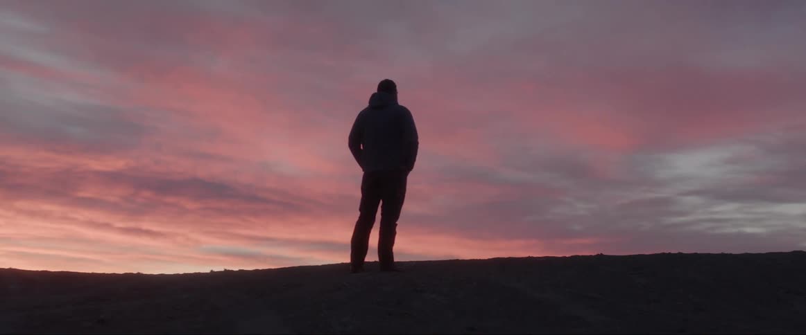 A man admiring the orange sky during sunset
