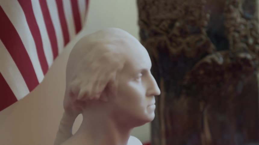 Ceramic sculpture of a man with the american flag behind him