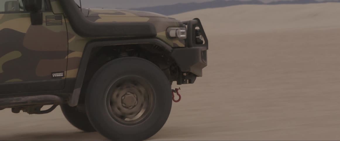 Jeep truck at high speed through the desert dunes