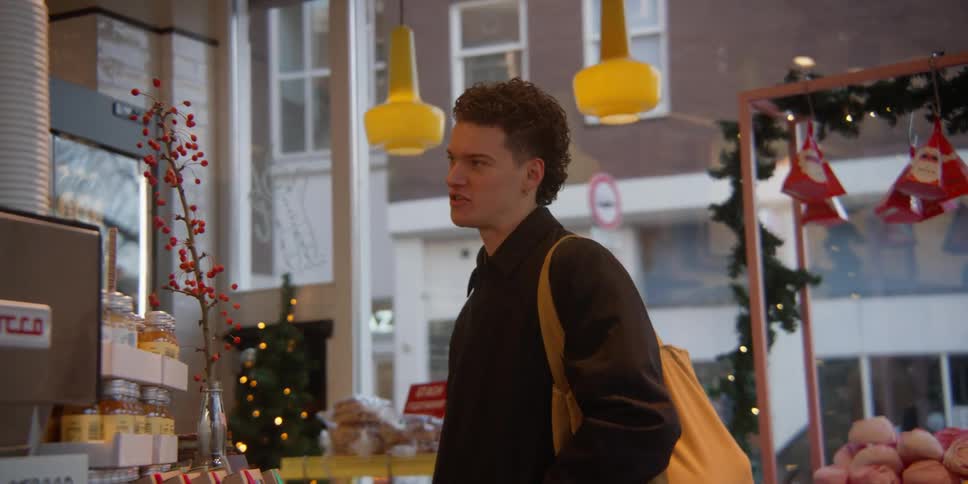 Man entering a cafe and using his cell phone