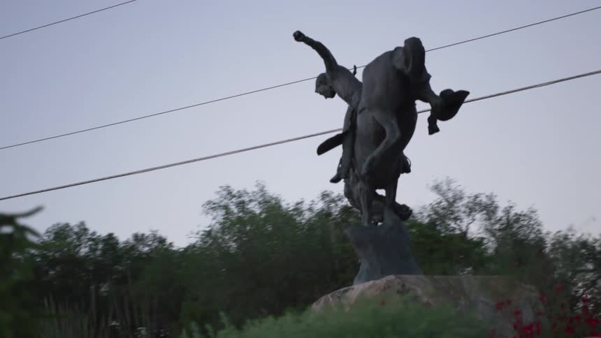 Monument of a person taming an animal in the middle of a square
