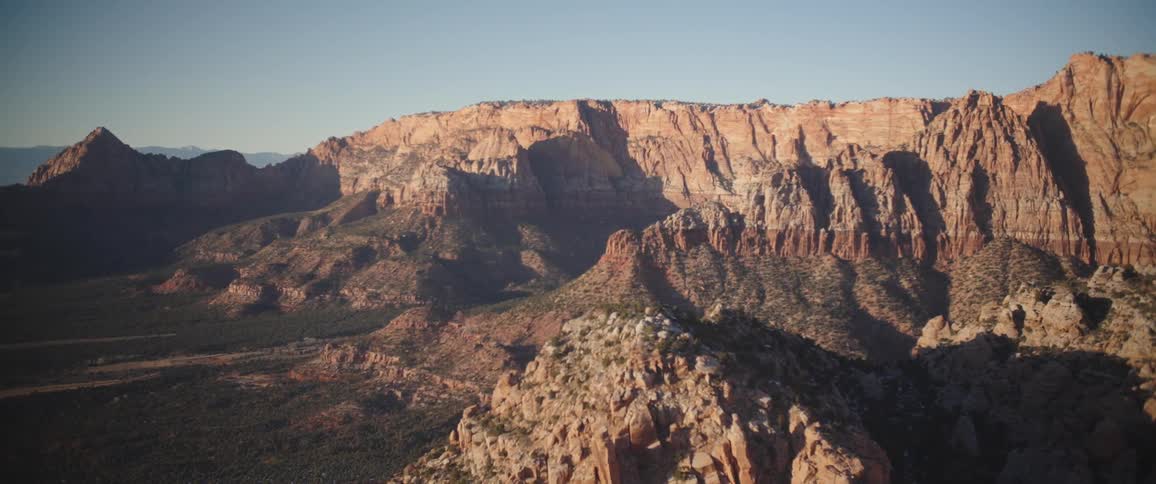 Sunlight shining on a mountain range with rugged rock formations
