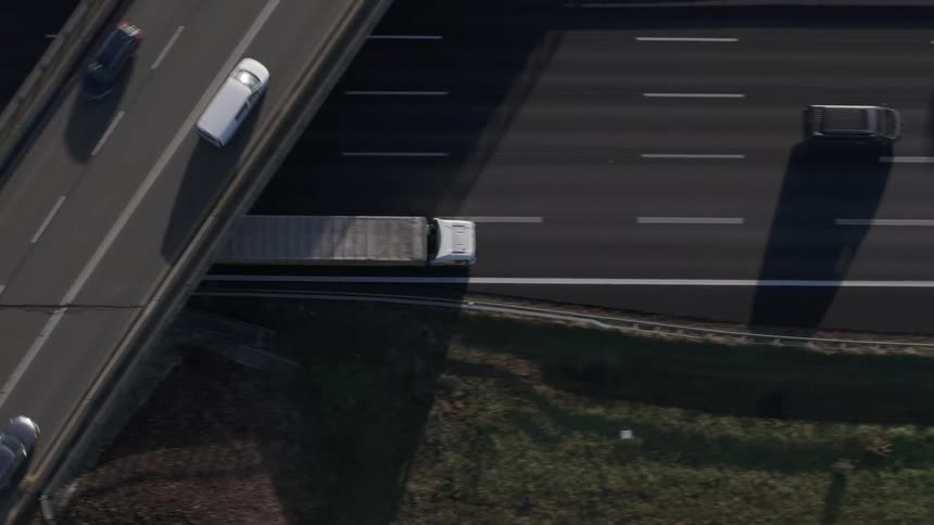 Low aerial over munich top of scattered vehicles on a fivelane freeway that runs under a threelane highway overpass