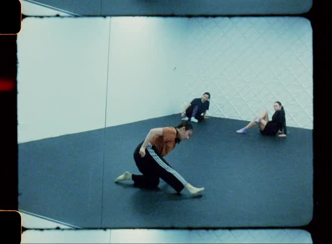 A girl dances in a room as two other girls watch