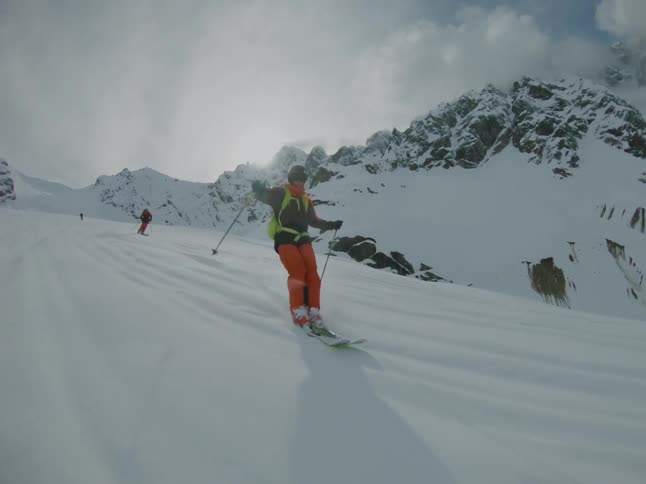 A skier riding powder during the day