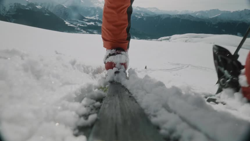 POV Closeup of a persons legs skitouring a snow-covered mountain